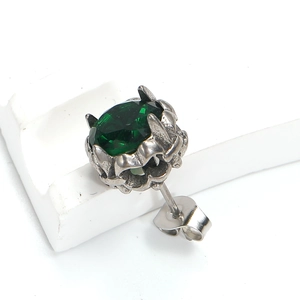 Gros plan sur un clou d'oreille avec gemme verte facettée et finition argent antique