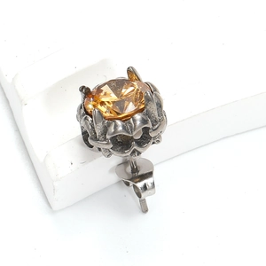 Détail macro d'une boucle d'oreille ambre et zircon avec sertissage gothique argenté