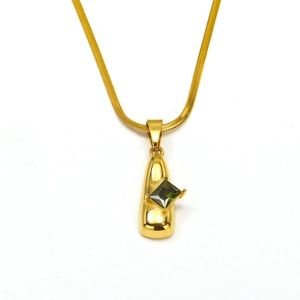 Detalle del collar de cadena dorada con colgante de piedra preciosa verde