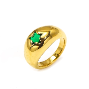 Detailed view of chunky golden dome ring featuring a sparkling green star-shaped gemstone