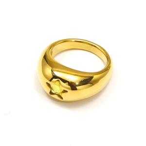 Close-up of wide gold-plated ring with inset yellow star-shaped faceted gemstone