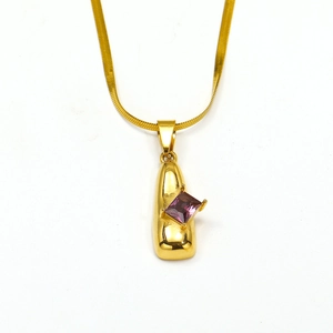 Detalle de collar con colgante geométrico dorado y piedra preciosa morada cuadrada