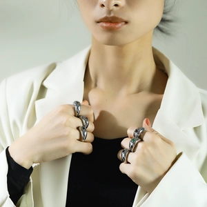 Modern silver irregular ring set with green and black accents on female model