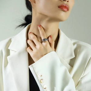 Polished silver ring featuring a hollow star design worn with a white professional blazer