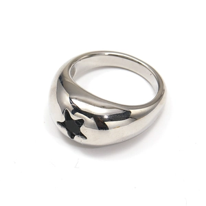 Macro detail of silver stainless steel wide ring featuring star cutout and black stone inlay