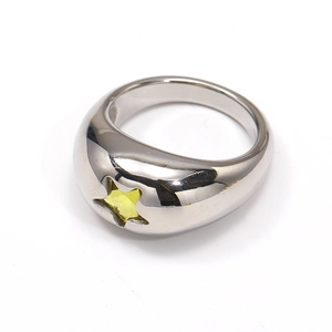Detailed macro view of silver star ring featuring an inlaid yellow star-shaped gemstone