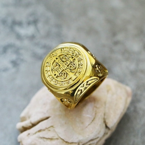 Macro-detail van de gouden Sint-Benedictus medaille ring met kruisgravure en reliëf