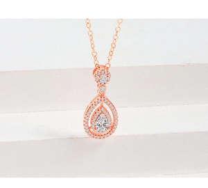 Macro view of rose gold pear-shaped double-layered pendant with pavé set crystals