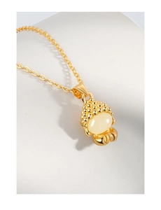Vue détaillée du pendentif plaqué or ancien avec calcédoine blanche et motif Bouddha