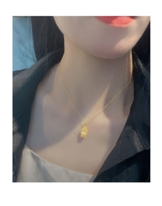 Gros plan du collier avec pendentif Bouddha doré porté pour un style élégant