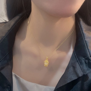 Collier tête de Bouddha dorée avec pendentif calcédoine blanche sur mannequin