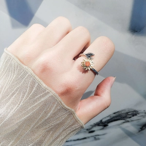 Bague tournesol ajustable avec pétales dorés et cristaux portée par un mannequin de main