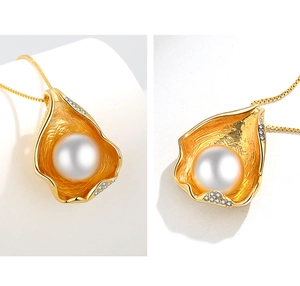 Detail of irregular gold leaf pendant with large white pearl and zircon accents