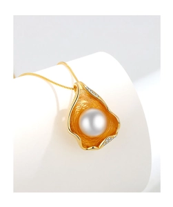 Detailed close-up of golden shell pendant necklace with pearl and micro-pave diamonds