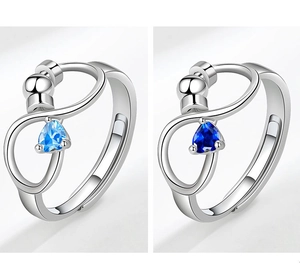 Detail view of anti-stress rotating rings with blue gemstones and infinity symbol design