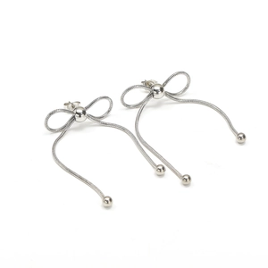 Detalle de pendientes de lazo con cadena de serpiente y borlas plateadas