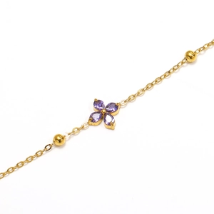 Detailed macro view of gold clover bracelet with purple marquise zircon stones