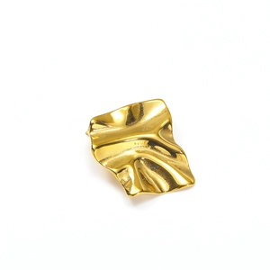 Detalle macro de pendientes geométricos bañados en oro con un acabado metálico pulido