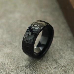 Detail eines schwarzen Titanrings mit gehämmerter Wabenstruktur und polierter Innenseite