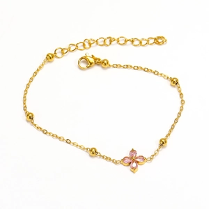 Detail of gold four-leaf clover bracelet with pink crystals and adjustable clasp link