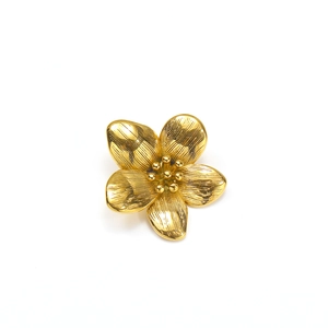 Detalle de pendientes de flor bañados en oro con textura de metal cepillado y detalle central