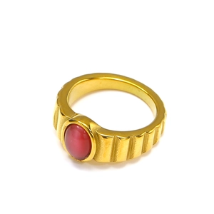 Dettaglio anello placcato oro 18k con gemma ovale rossa e fascia con texture
