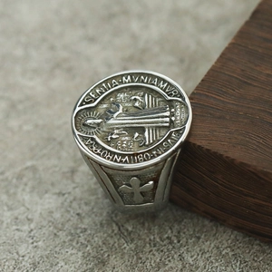 Détail macro d'une bague médaille de Saint Benoît vintage en acier inoxydable avec gravures