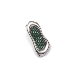 Detalle macro del colgante orgánico plateado con piedras preciosas verdes engastadas