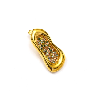 Detalle de pendientes geométricos bañados en oro de 18k con cristales de colores y circonitas