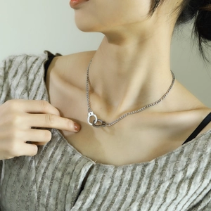 Chic silver titanium steel necklace featuring detailed handcuff pendant on male model