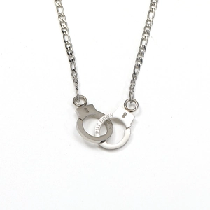 Detail of silver handcuffs pendant with PUT DOWN and LOCK engravings on Figaro chain