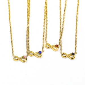 Detail of four infinity gold necklaces featuring pink blue orange and black gemstones