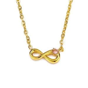 Detail of infinity gold pendant with pink cubic zirconia on a polished metal chain