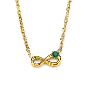 Detail of infinity gold necklace featuring a round green zircon pendant on white background