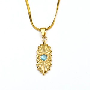 Macro detail van 18K gouden hanger met blauwe kattenoogsteen aan een slangenketting