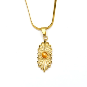 Detail van 18K goud roestvrijstalen ketting met zonnestraal hanger en amber steen