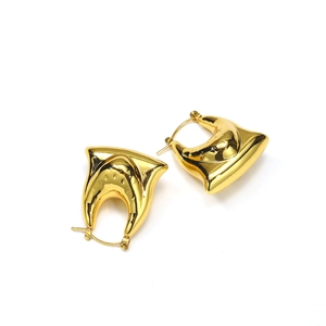 Gros plan de boucles d'oreilles en U dorées polies avec une finition miroir lisse