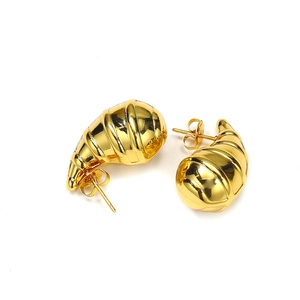 Détail des boucles d'oreilles croissant dorées avec texture en spirale polie