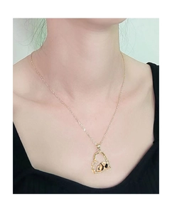 Dettaglio della collana con ciondolo a panda a forma di cuore dorato con incisione