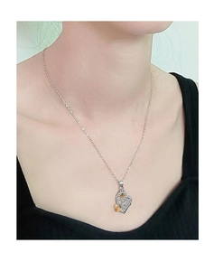Dettaglio della collana a cuore con girasole e ape dorati indossata da modella