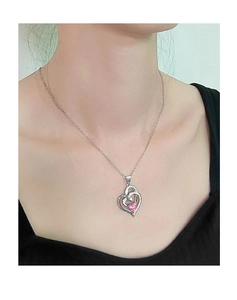 Dettaglio collana a doppio cuore con gemma rosa e alone di cristalli indossata