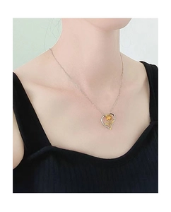 Dettaglio della collana con pendente a cuore e rosa dorata indossata dal modello