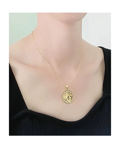Primo piano di una collana d'oro con ciondolo panda e albero della vita su modella