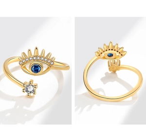 Macro detail of gold Evil Eye ring with blue sapphire and sparkling white crystals
