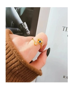 Close-up of golden evil eye ring with blue stone and zirconia on fashion magazine