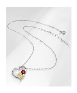 Dettaglio del ciondolo a cuore con coccinella, fiori e incisione Love You To The Moon