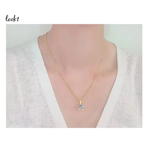 Gros plan du pendentif classique en Moissanite sur une élégante chaîne en or 18k