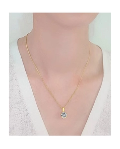 Gros plan d'un collier en or 18K minimaliste avec pendentif solitaire moissanite taille brillant