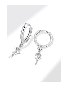 Détail des créoles argentées avec pendentif en étoile et pierre de zircon centrale