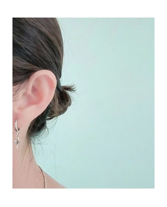 Gros plan d'une boucle d'oreille anneau argentée avec pendentif étoile pour homme